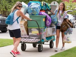 ECU freshman Murphy Credle gets some help from her mother, Ann, as they move a large cart of room supplies in Greene Residence Hall on Wednesday, August 16, 2017. (Photo by Rhett Butler)